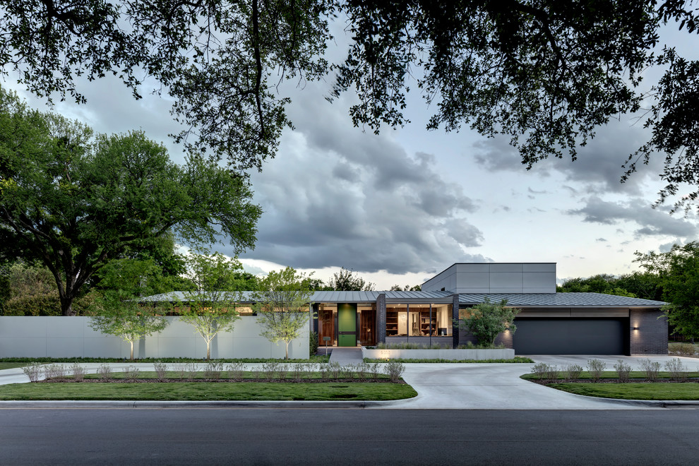 Large contemporary gray two-story brick house exterior idea in Dallas with a shed roof and a metal roof
