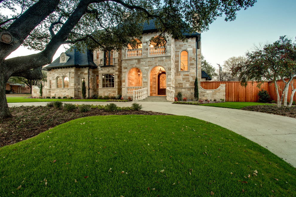 This is an example of a large traditional two floor house exterior in Dallas with stone cladding.