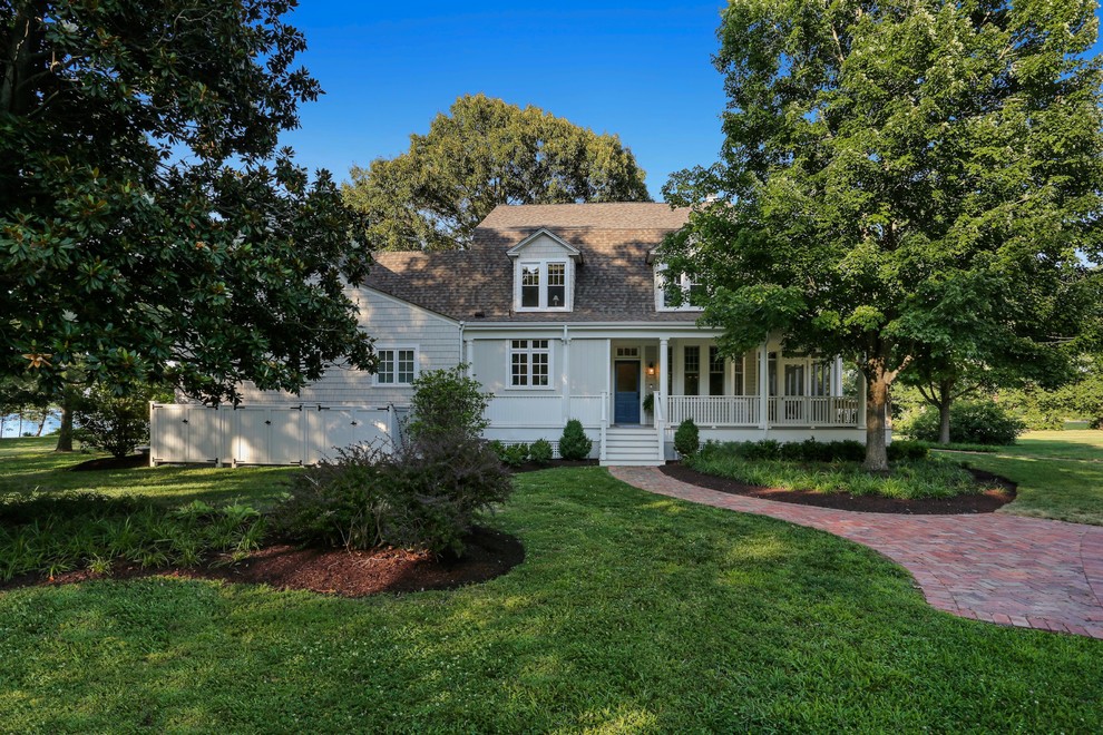 Large cottage beige two-story wood house exterior photo in DC Metro with a gambrel roof and a shingle roof