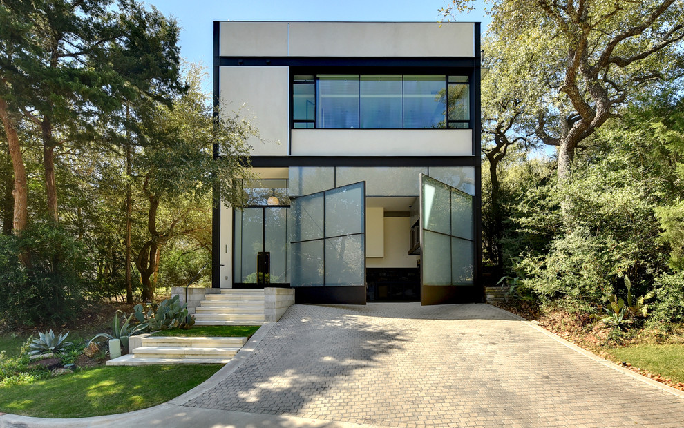 Ejemplo de fachada de casa beige contemporánea de dos plantas con revestimientos combinados y tejado plano