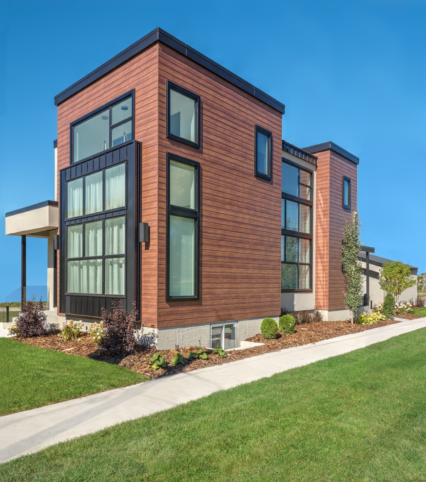 Пример оригинального дизайна: двухэтажный, коричневый дом среднего размера в стиле модернизм с облицовкой из металла и плоской крышей