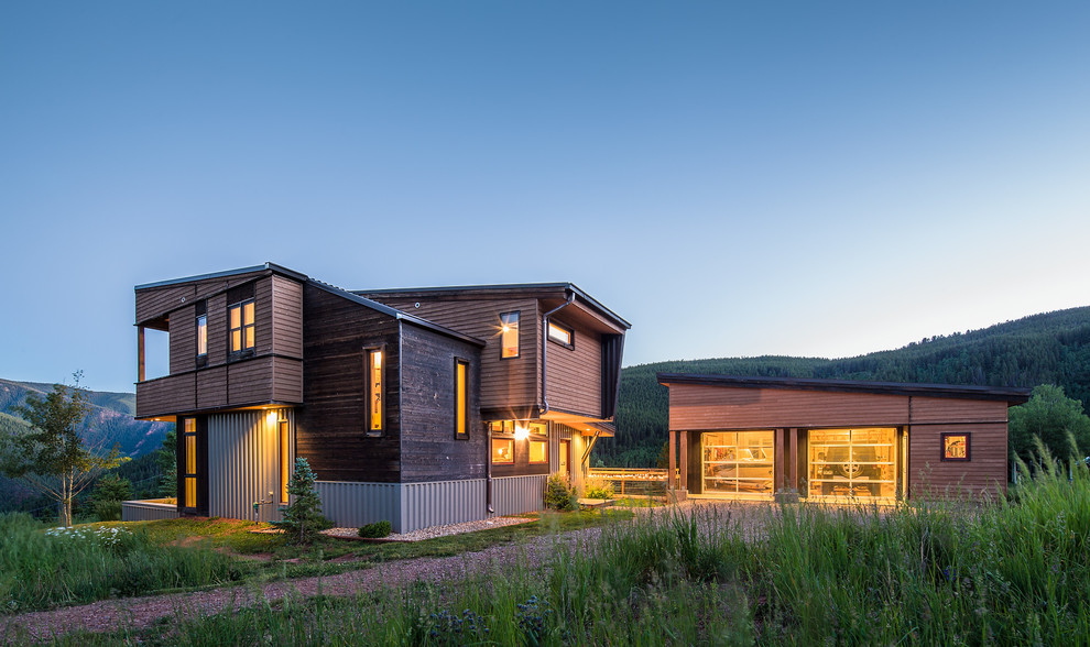 Brown rustic two floor house exterior in Denver with wood cladding and a lean-to roof.