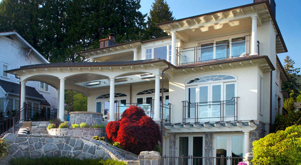 Immagine della villa beige contemporanea a tre piani di medie dimensioni con rivestimento in pietra, tetto piano e copertura mista