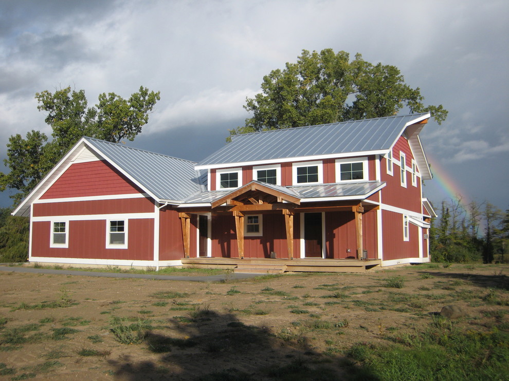 На фото: маленький, двухэтажный, красный дом в стиле кантри с облицовкой из ЦСП для на участке и в саду