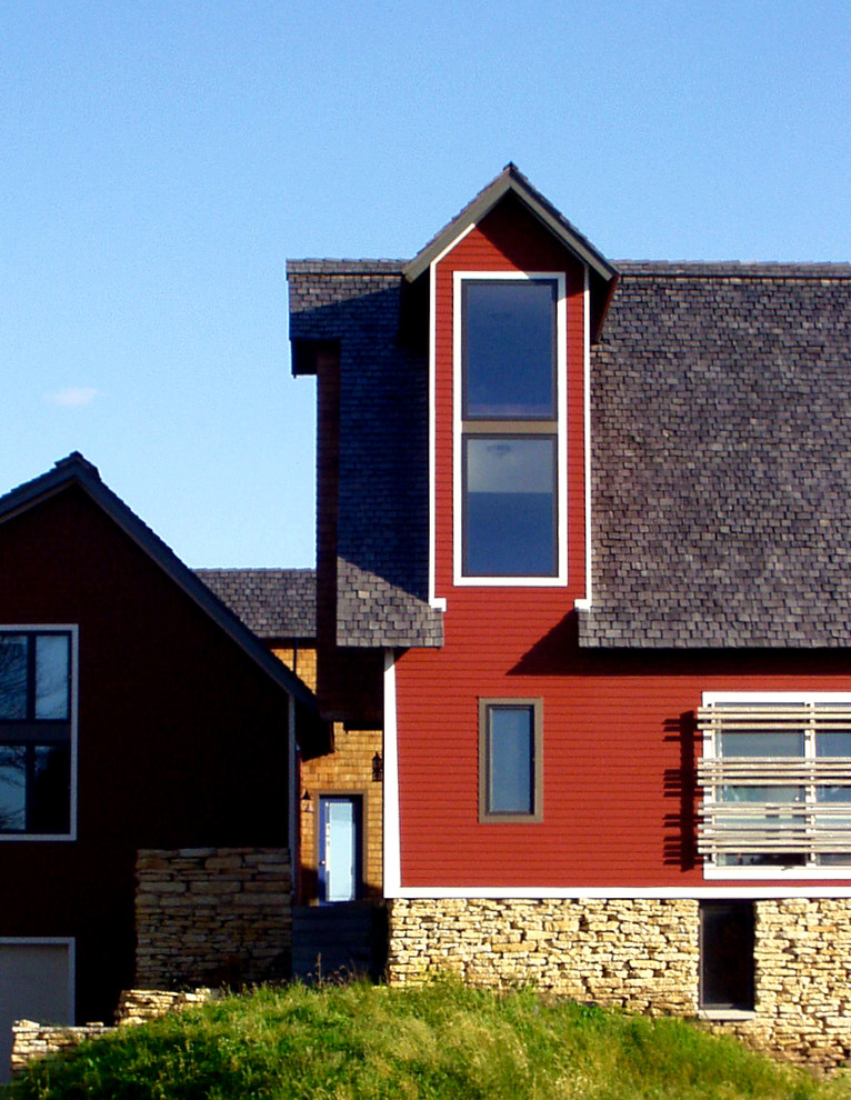 Ejemplo de fachada roja de estilo de casa de campo con revestimiento de madera