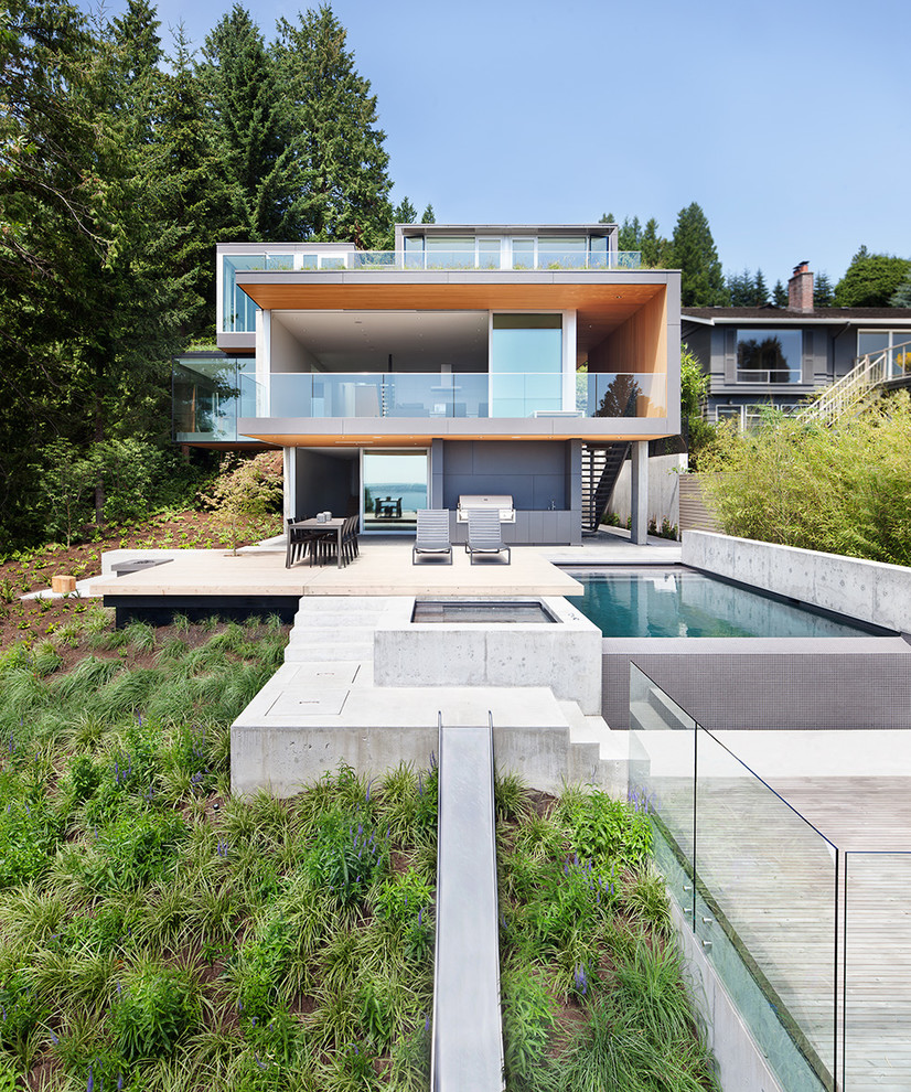 На фото: трехэтажный дом в стиле модернизм с плоской крышей