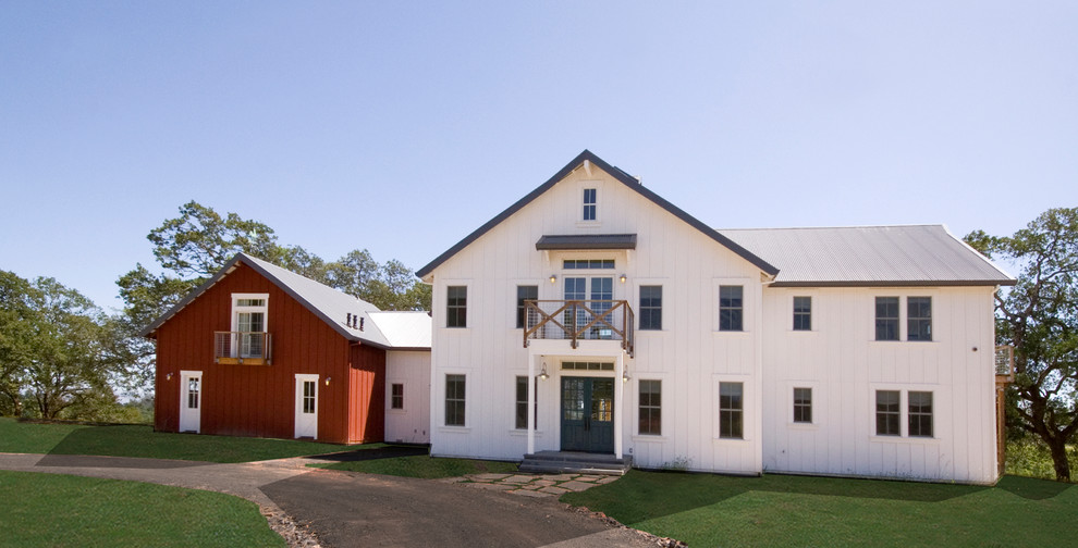 Foto della facciata di una casa bianca country a due piani di medie dimensioni con rivestimento in legno