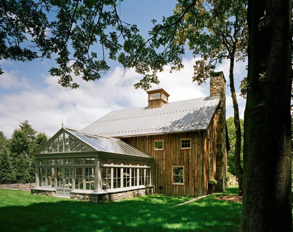 Exemple d'une grande façade de grange rénovée marron nature en bois à un étage avec un toit à deux pans.
