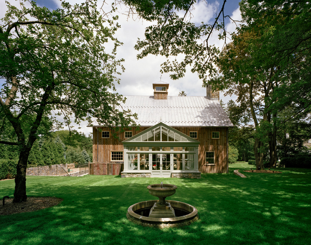 Стильный дизайн: большой, двухэтажный, деревянный, коричневый барнхаус (амбары) дом в стиле кантри с двускатной крышей - последний тренд