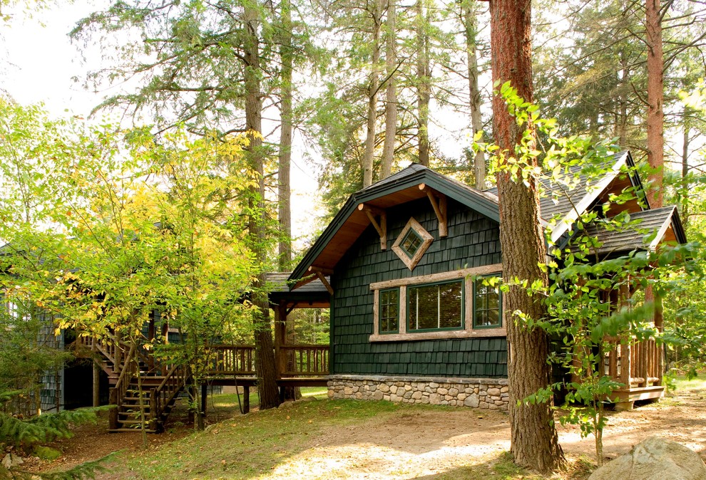 Idées déco pour une façade de maison verte montagne en bois avec un toit à croupette.