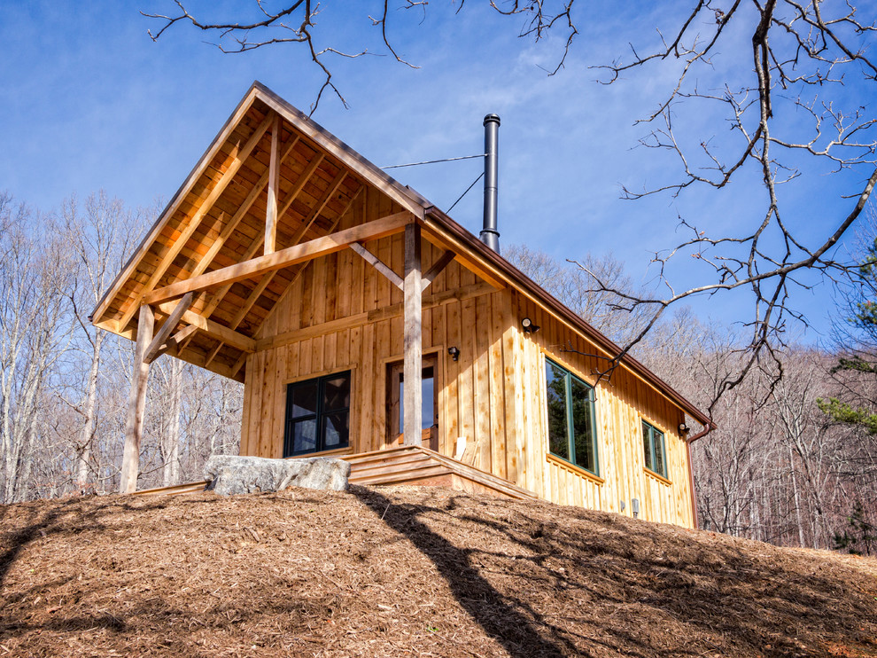 Cette photo montre une façade de maison marron montagne en bois de taille moyenne et à un étage avec un toit à deux pans.