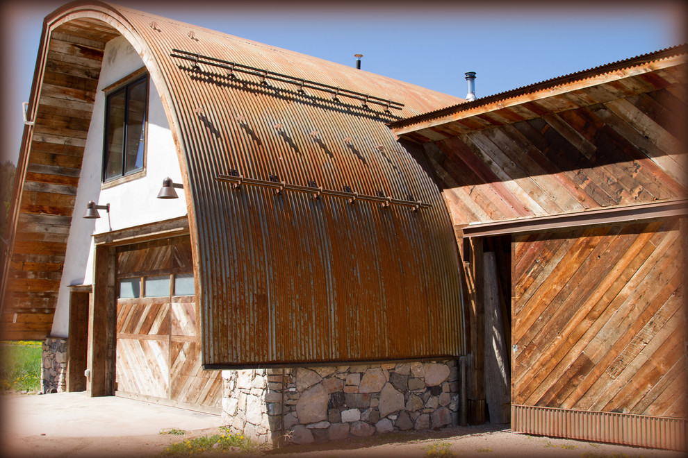 Diseño de fachada de casa blanca rural con revestimientos combinados, tejado a dos aguas y tejado de metal
