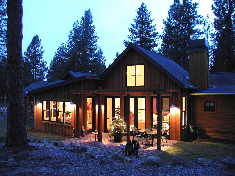 Réalisation d'une façade de maison chalet en bois de taille moyenne et à un étage avec un toit à deux pans.