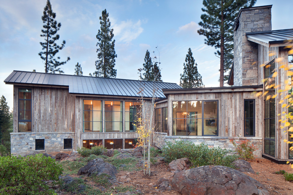 Cette image montre une grande façade de maison chalet en bois avec un toit en métal.