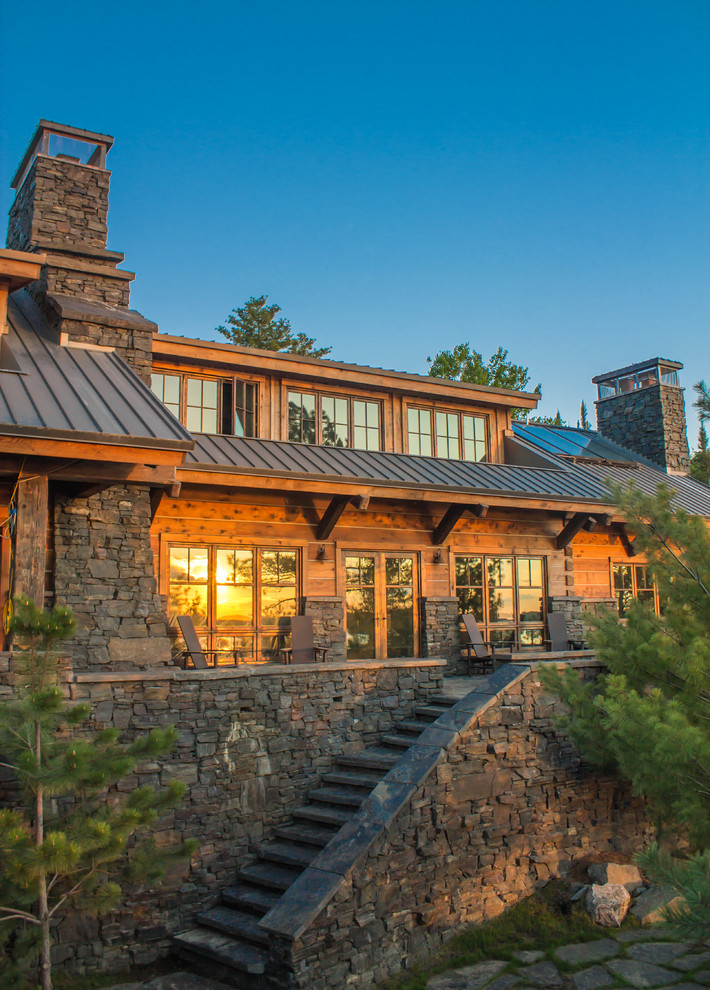 Photo of a rustic two floor house exterior in Minneapolis with wood cladding and a pitched roof.