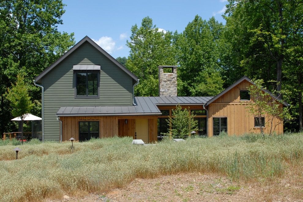 Foto de fachada de casa multicolor rústica de dos plantas con tejado a dos aguas, tejado de metal y revestimientos combinados