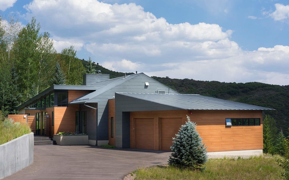 Cette photo montre une façade de maison multicolore montagne avec un revêtement mixte et un toit en métal.