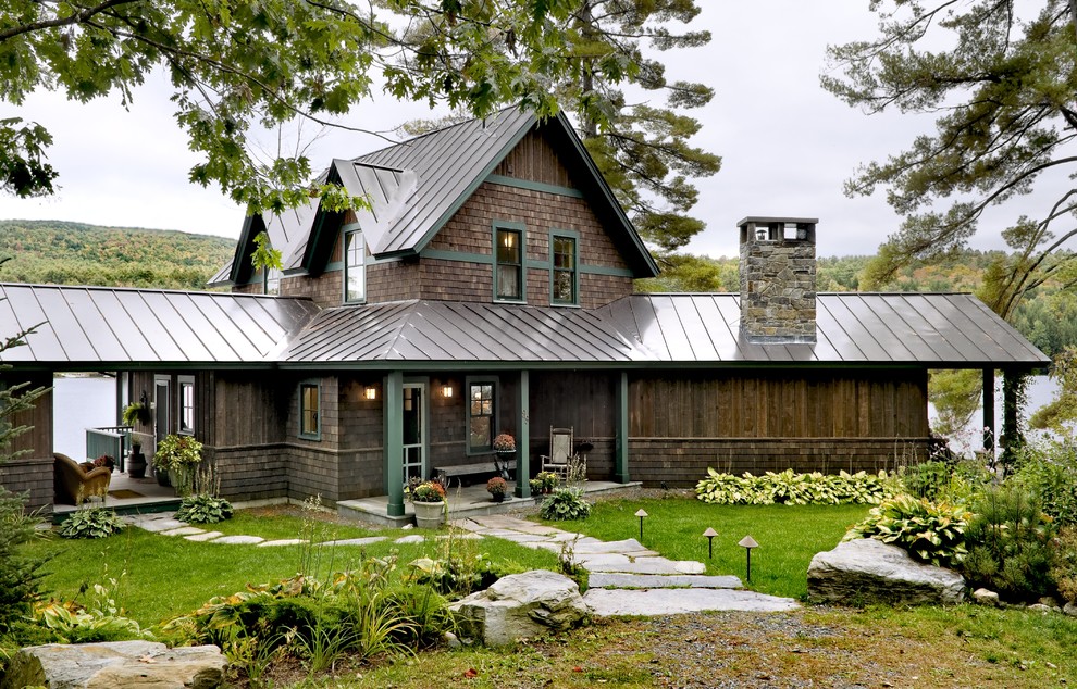 Design ideas for a rustic house exterior in Burlington with wood cladding and a metal roof.