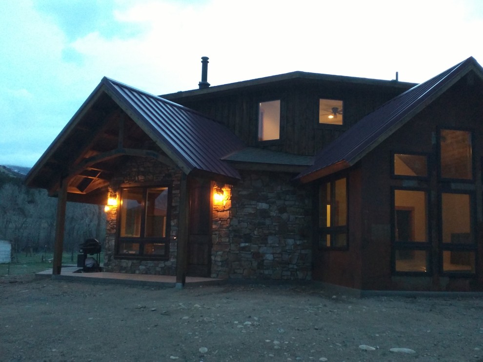 Ejemplo de fachada de casa gris campestre de tamaño medio de dos plantas con revestimientos combinados, tejado plano y tejado de metal