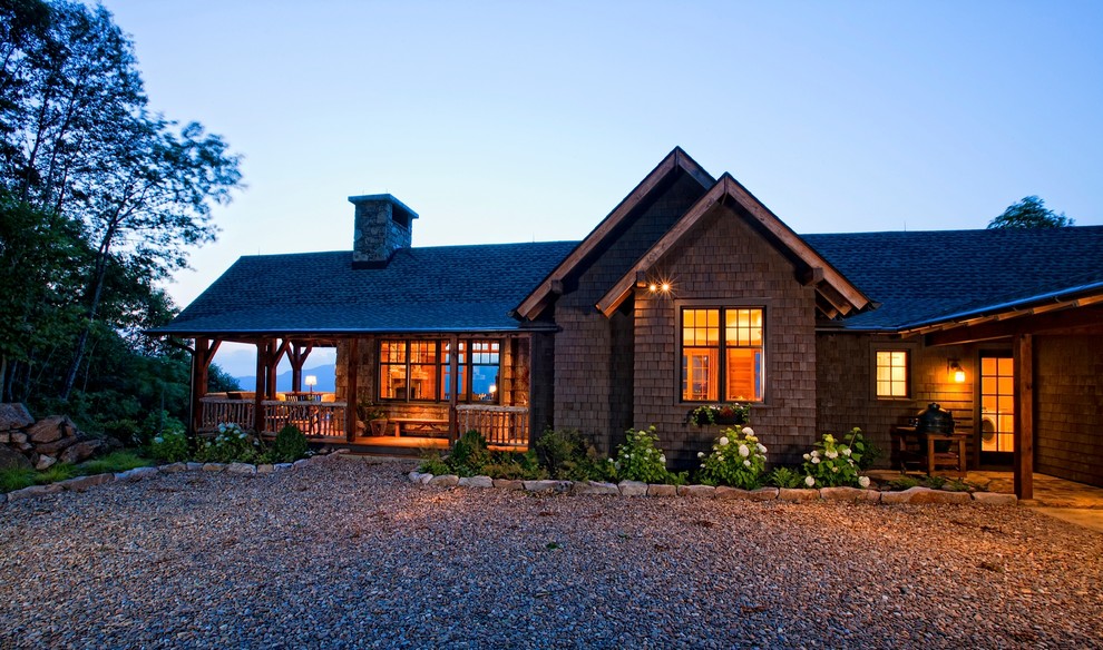 Cette image montre une façade de maison marron chalet en bois de taille moyenne et de plain-pied avec un toit à deux pans et un toit en shingle.