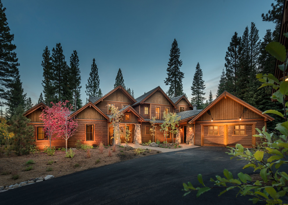 Стильный дизайн: огромный, одноэтажный, деревянный, коричневый дом в стиле рустика с двускатной крышей - последний тренд