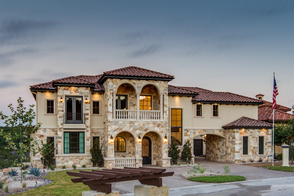 Inspiration for a large mediterranean three-story stone exterior home remodel in Austin