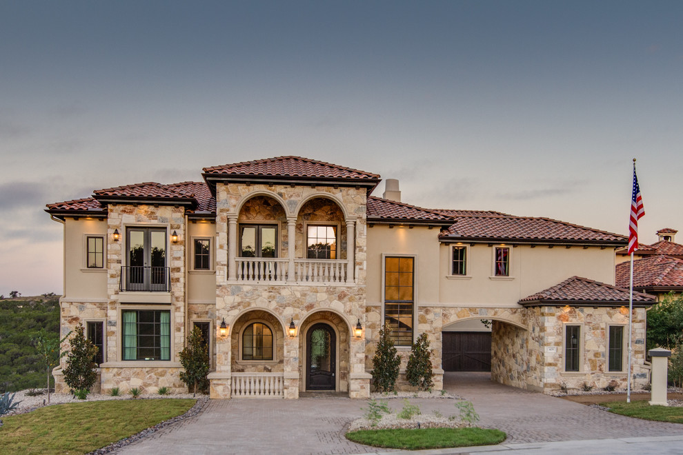 Example of a large tuscan three-story stone exterior home design in Austin