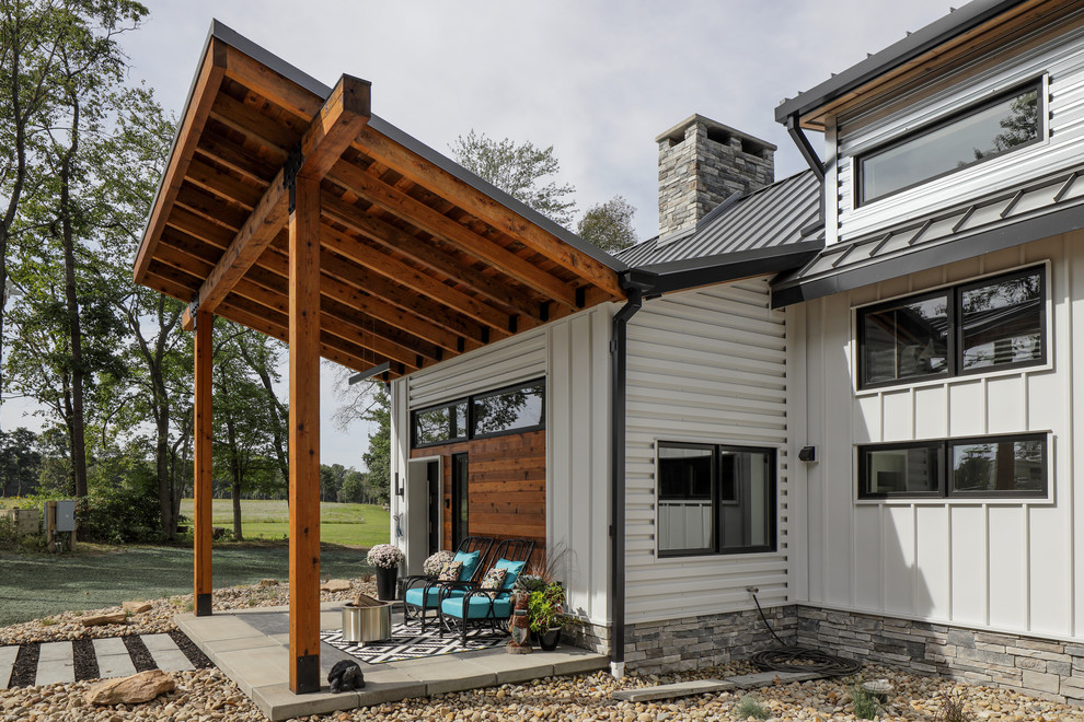 Diseño de fachada de casa blanca rural grande de dos plantas con revestimiento de metal, tejado a dos aguas y tejado de metal