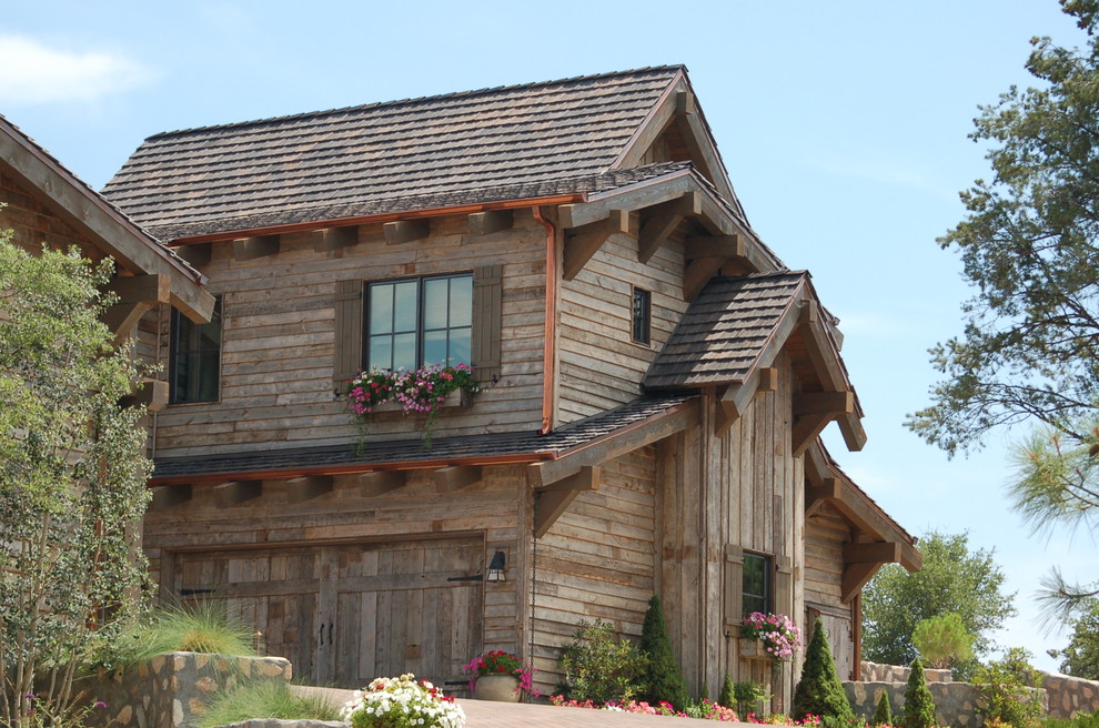 Modelo de fachada beige rural extra grande de dos plantas con revestimiento de madera y tejado a dos aguas