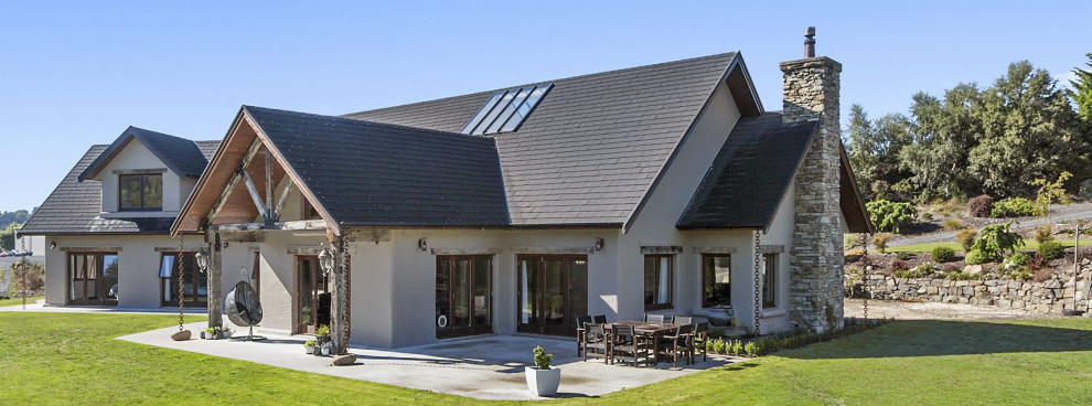 Foto de fachada de casa beige rural de dos plantas con revestimientos combinados y tejado a cuatro aguas