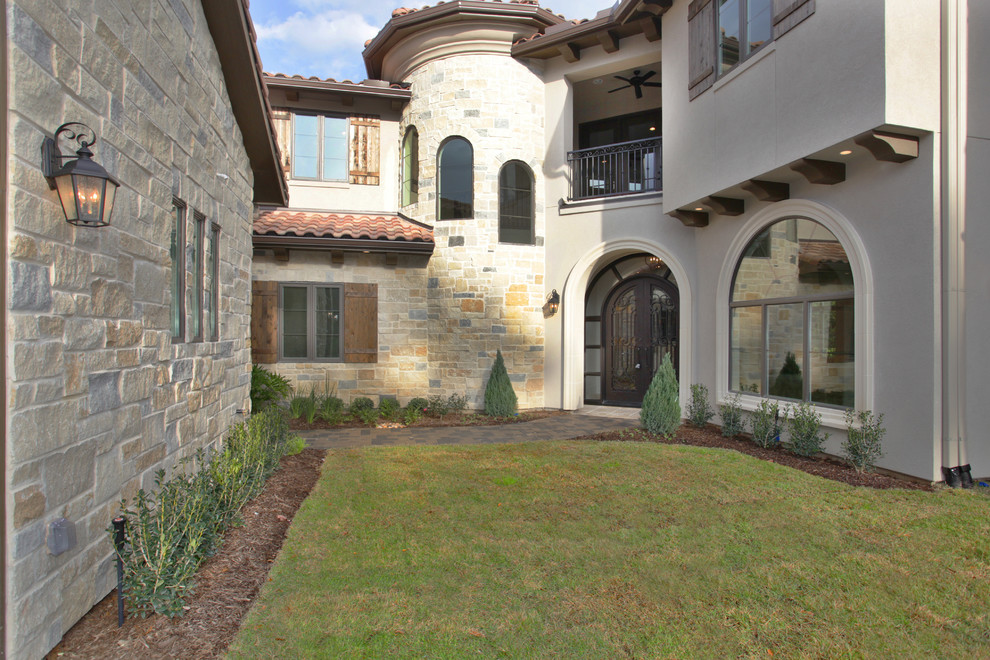 Photo of a large mediterranean two floor render house exterior in Houston.