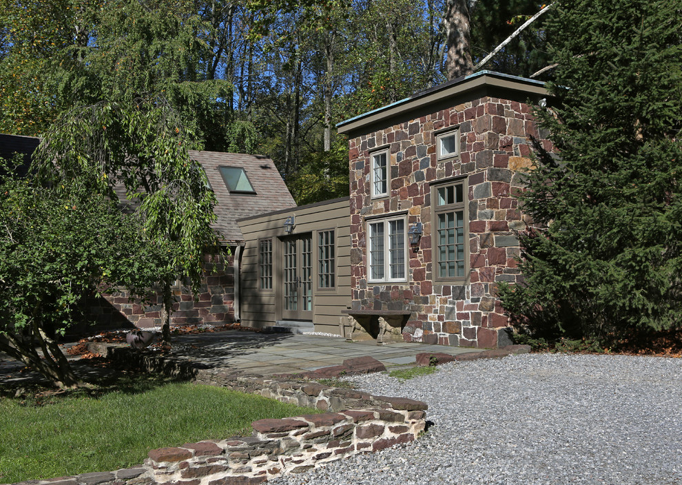 Cette image montre une façade de maison rustique en pierre de taille moyenne et de plain-pied avec un toit à deux pans et un toit en shingle.