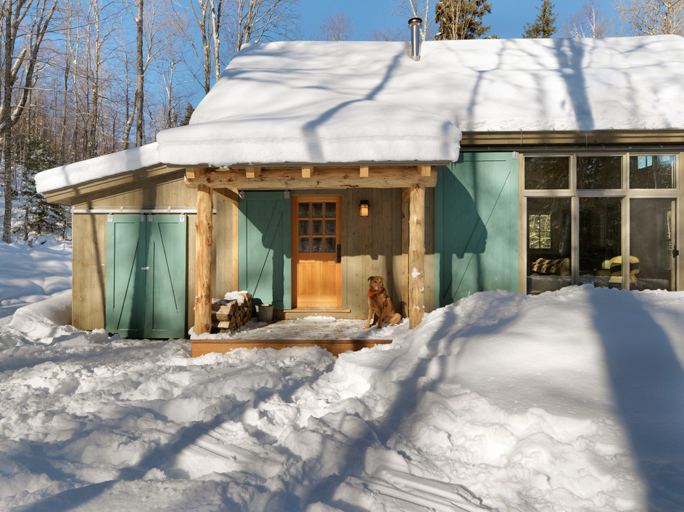 Small and beige rustic bungalow house exterior in Burlington with wood cladding and a pitched roof.