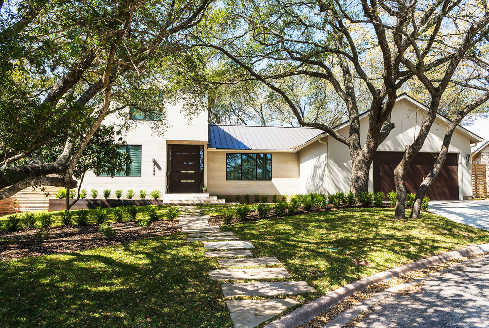 Photo of a beige classic two floor house exterior in Austin.