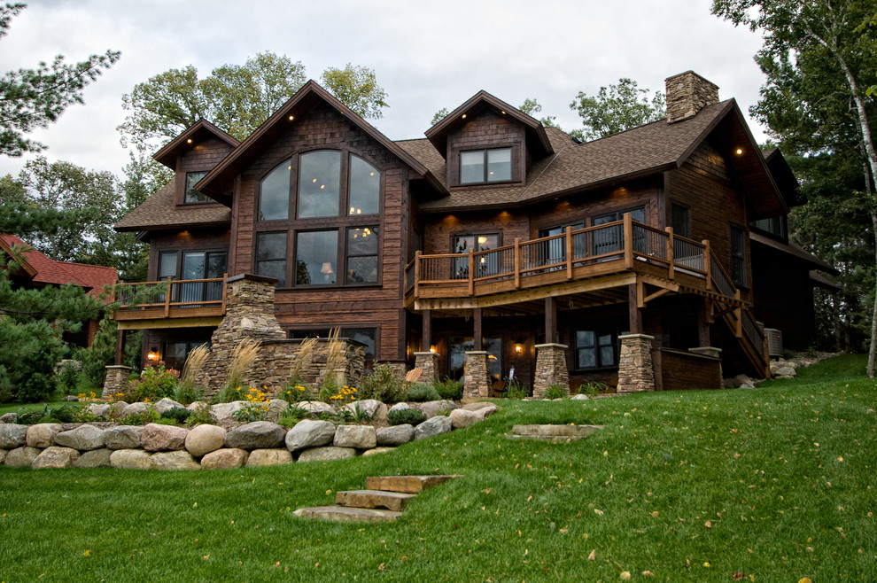 Inspiration pour une grande façade de maison marron chalet en bois à deux étages et plus avec un toit à deux pans.