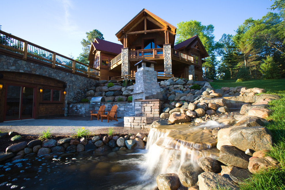 Photo of a large and brown classic house exterior in Minneapolis with three floors, wood cladding and a pitched roof.