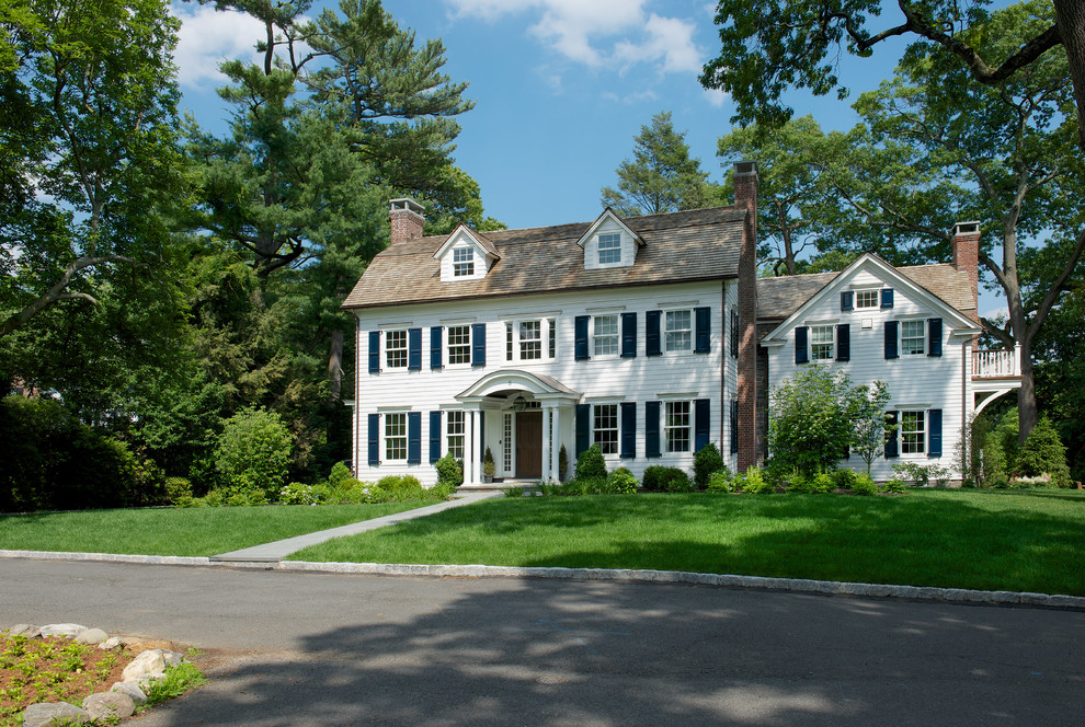 Cette image montre une grande façade de maison blanche traditionnelle à un étage avec un revêtement en vinyle et un toit à deux pans.