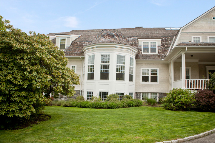 Exemple d'une grande façade de maison beige chic à deux étages et plus avec un revêtement en vinyle.