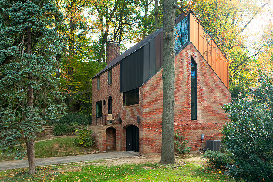 Idée de décoration pour une façade de maison métallique minimaliste à deux étages et plus avec un toit à deux pans.