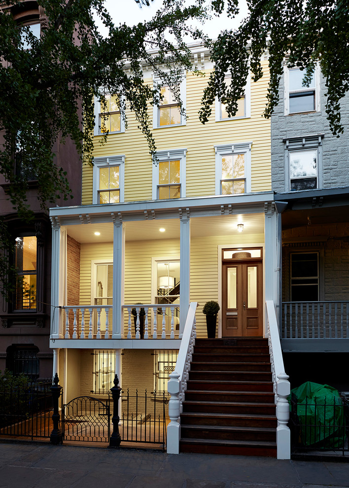 Mittelgroßes, Dreistöckiges Modernes Haus mit gelber Fassadenfarbe und Flachdach in New York