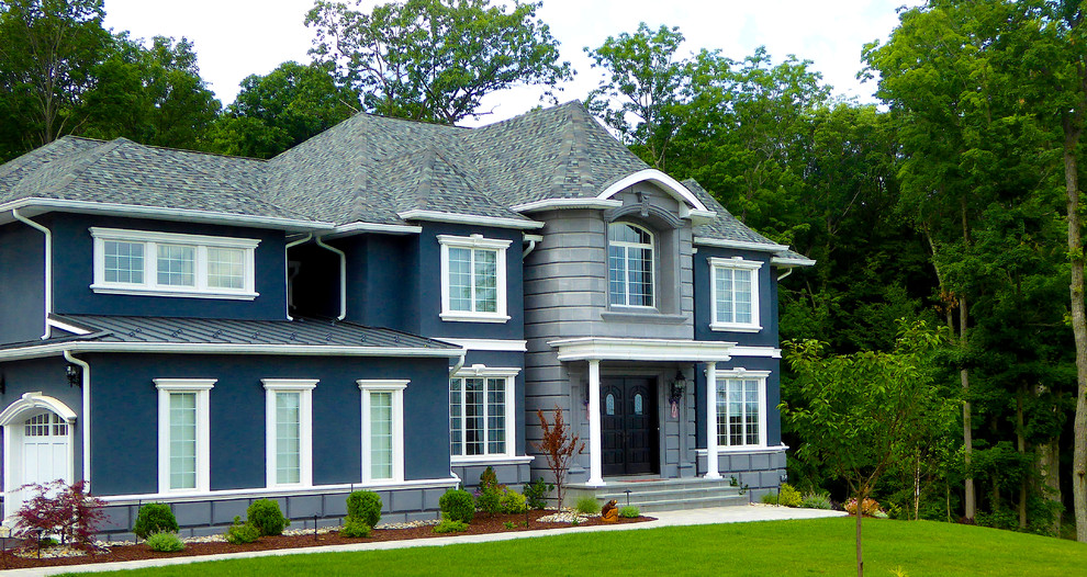 Пример оригинального дизайна: большой, двухэтажный, синий дом в стиле фьюжн с облицовкой из цементной штукатурки и вальмовой крышей