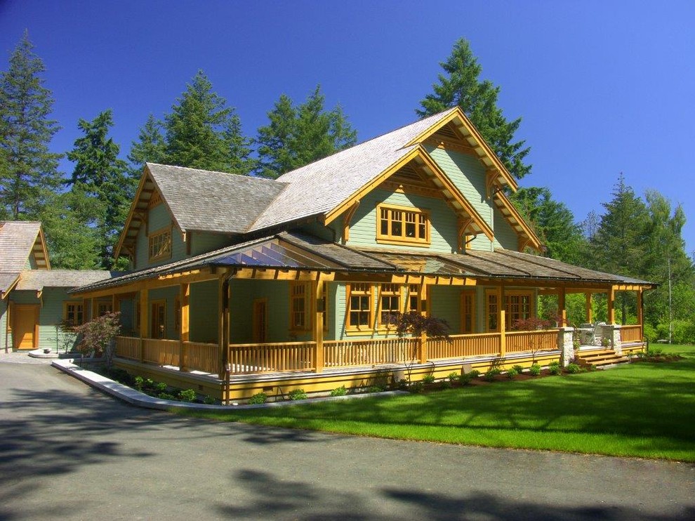 Imagen de fachada verde de estilo de casa de campo grande de dos plantas con revestimiento de vinilo y tejado a dos aguas