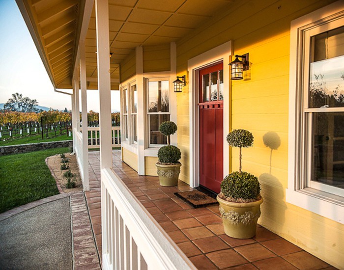 Ejemplo de fachada amarilla de estilo de casa de campo de dos plantas con revestimiento de madera y tejado plano