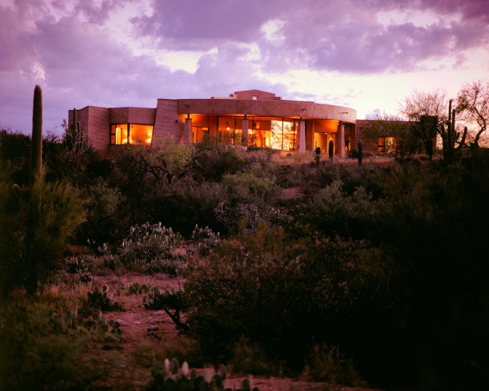 This is an example of a large and beige contemporary bungalow clay house exterior in Phoenix with a flat roof.