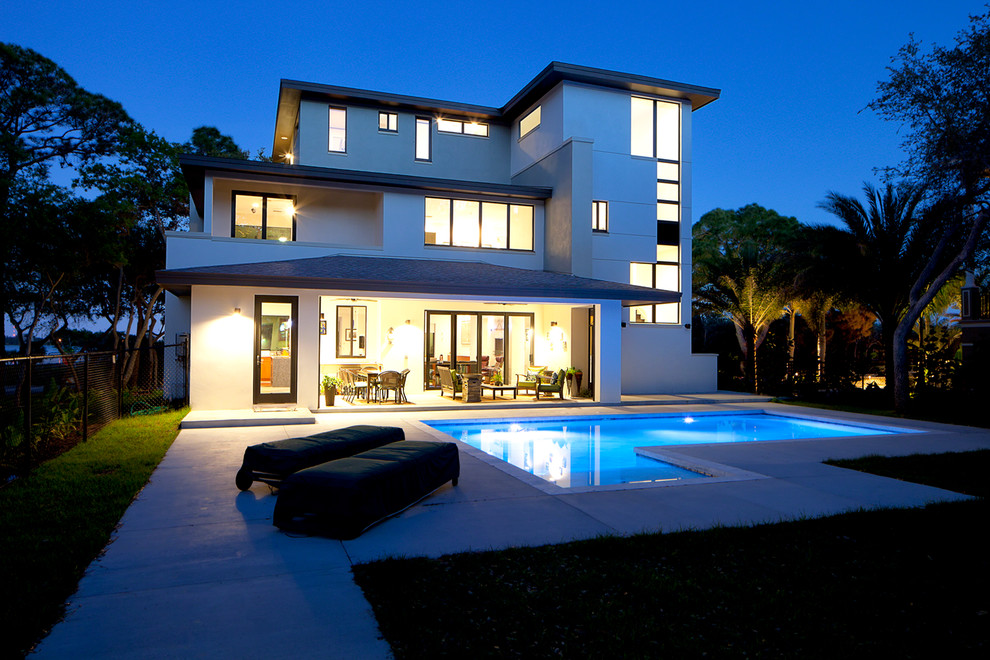 Diseño de fachada beige minimalista grande de tres plantas con revestimiento de estuco y tejado plano