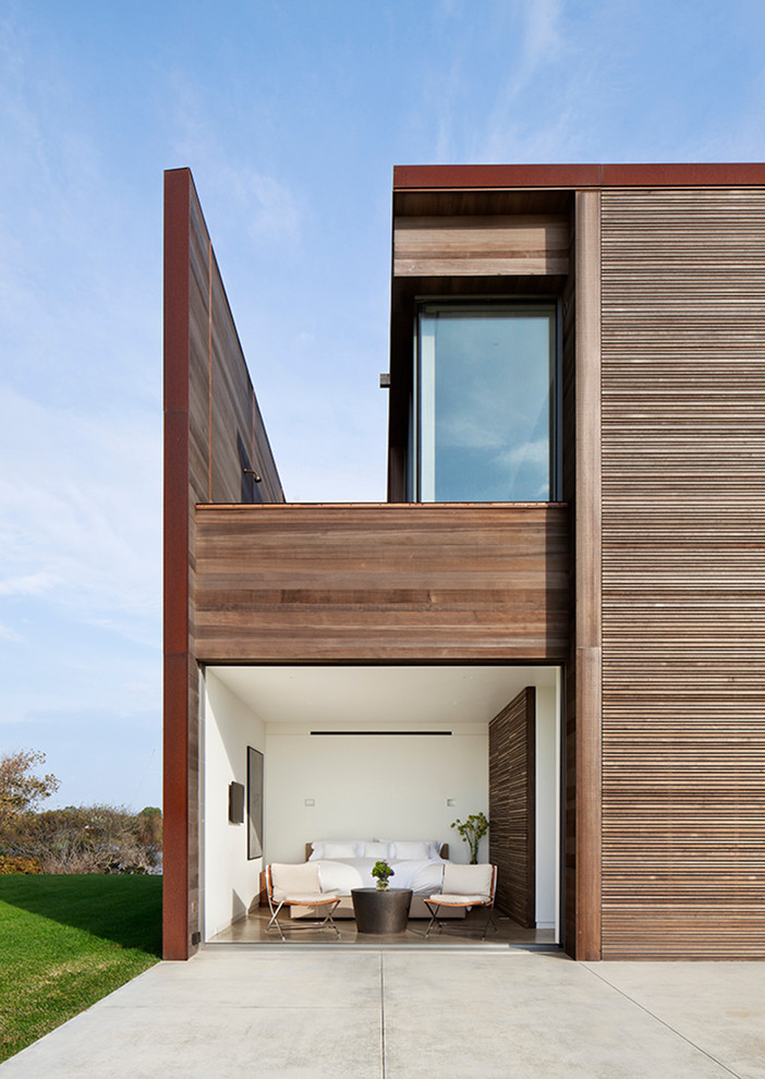 Foto della facciata di una casa contemporanea a due piani con rivestimento in legno e tetto piano