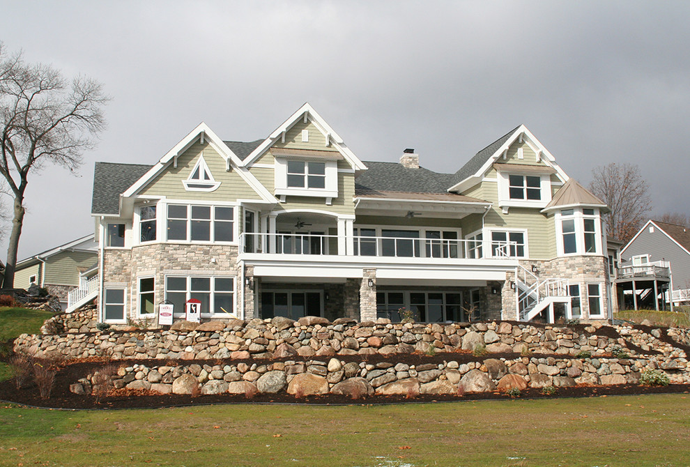 Стильный дизайн: большой, двухэтажный, зеленый дом в морском стиле с облицовкой из ЦСП и двускатной крышей - последний тренд