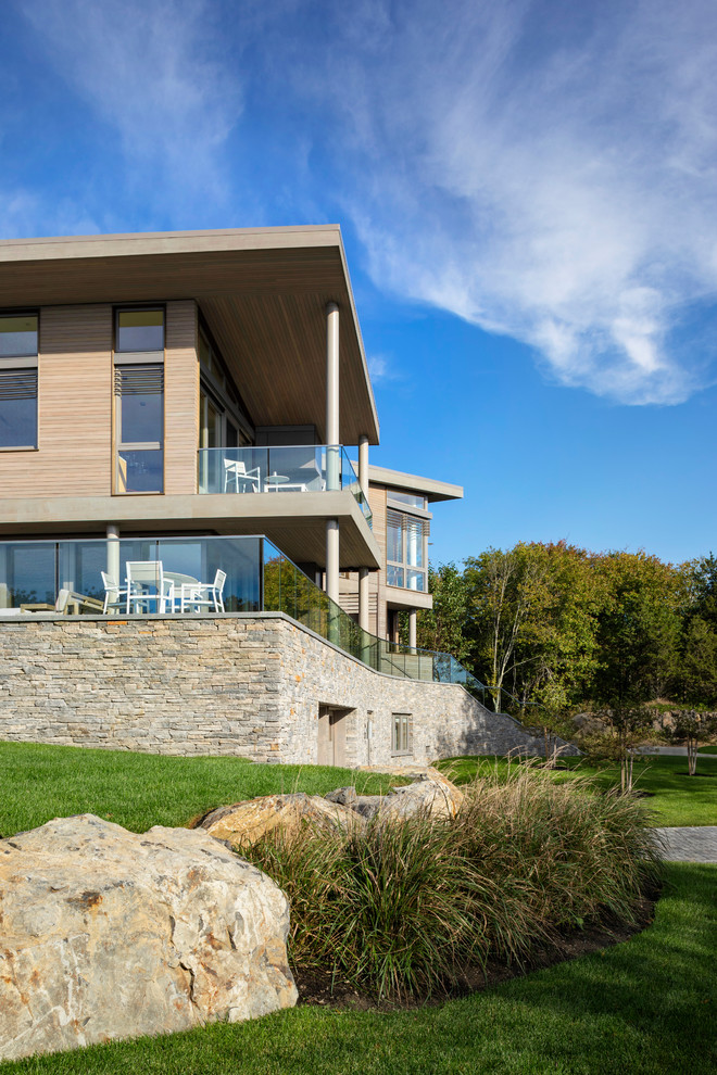 Réalisation d'une grande façade de maison grise minimaliste en bois à deux étages et plus avec un toit en appentis.