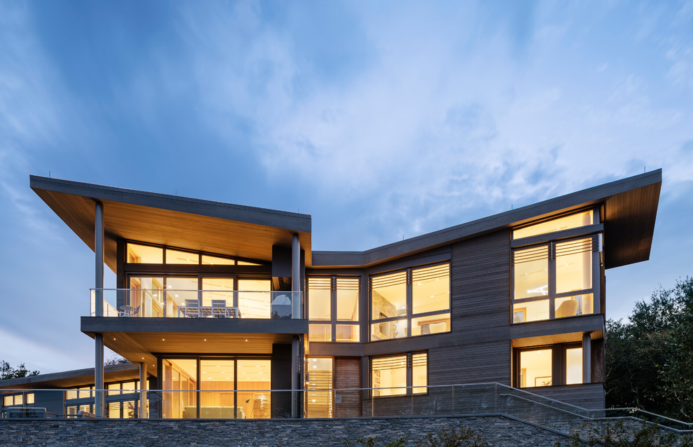 На фото: большой, трехэтажный, деревянный, серый частный загородный дом в стиле модернизм с плоской крышей