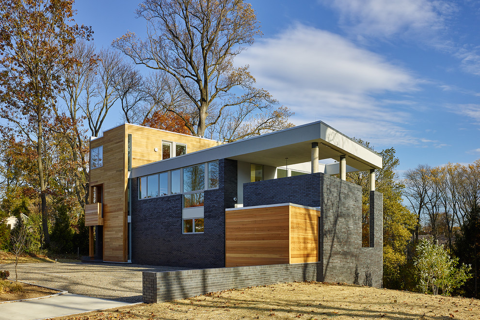 Idee per la facciata di una casa nera contemporanea a due piani di medie dimensioni con rivestimento in mattoni e tetto piano